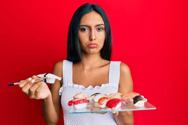 Young Brunette Woman Eating Butterfish Sushi Using Chopsticks Depressed Worry — Stock Photo, Image