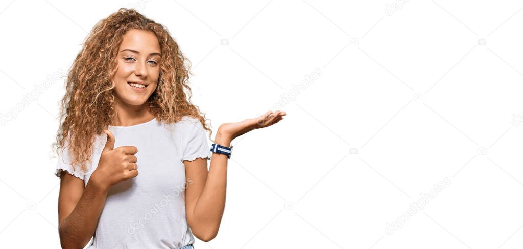 Beautiful caucasian teenager girl wearing casual white tshirt showing palm hand and doing ok gesture with thumbs up, smiling happy and cheerful 