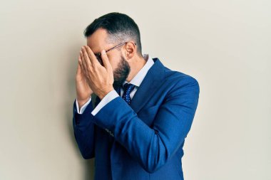 Sakallı, takım elbiseli, kravatlı, suratını ellerle kapatıp ağlayan genç bir adam. depresyon kavramı. 