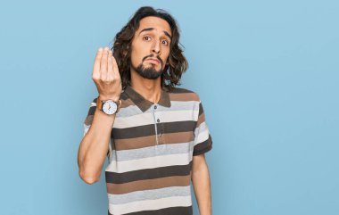 Gündelik kıyafetler giyen genç İspanyol adam İtalyan jesti yapıyor. El ve parmaklarıyla kendinden emin ifade ediyor. 