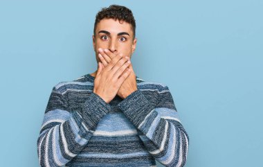 Günlük kıyafetler giyen İspanyol genç adam yanlışlıkla elleri ile ağzını kapatırken şok oldu. gizli kavram. 