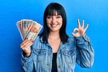 Genç İspanyol kadın elinde Mısır banknotları tutuyor. Parmaklarıyla imza atıyor, gülümsüyor. Mükemmel bir sembol. 