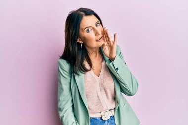 Orta yaşlı esmer kadın, günlük giysiler giymiş, el ele tutuşmuş, gizli söylentiler yayıyor, kötü niyetli konuşmalar fısıldıyor. 