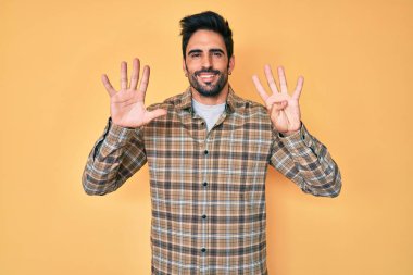 Yakışıklı, sakallı, günlük kıyafetler giyen, dokuz numaralı parmaklarıyla gösteriş yapan, kendine güvenen ve mutlu bir İspanyol.. 