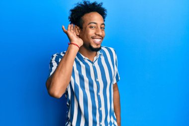 Sakallı, sıradan çizgili tişörtlü, ağzı kulaklarında dedikoduları ve dedikoduları dinleyen Afrikalı genç bir Amerikalı. Sağırlık kavramı. 