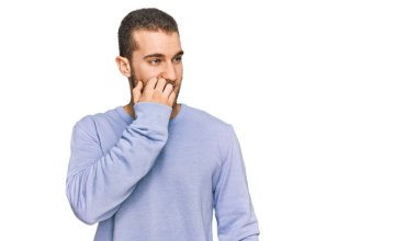 Günlük kıyafetler giyen genç beyaz adam gergin ve gergin görünüyor. Ağzı tırnak yiyen eller. anksiyete. 