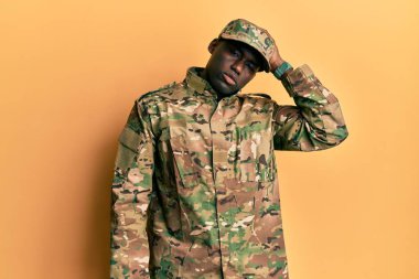 Asker üniforması giyen Afro-Amerikan genç bir adam, kafası karışıyor ve soru soruyor. Şüpheyle kararsız, kafa kafaya düşünerek. Düşünceli kavram. 