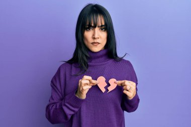 Kâküllü, elinde kırık bir kalp kâğıdı olan genç esmer kadın şüpheci ve gergin, sorun yüzünden suratını asıyor. negatif kişi. 