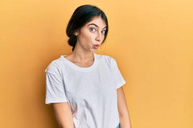 Gündelik beyaz tişört giyen genç beyaz kadın şaşırmak için ağzı açık kalmış, korkmuş ve hayrete düşmüştü. 