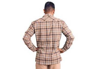 Gündelik kıyafetler giyen genç İspanyol adam kolları vücudunda geriye doğru bakıyor. 