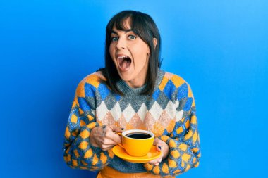 Genç İspanyol kadın bir fincan kahve içip çılgınlığı kutluyor ve başarıya hayret ediyor gözleri açık heyecanla haykırıyor. 