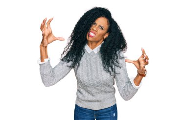 Orta yaşlı Afro-Amerikalı kadın günlük kıyafetler giyiyor öfkeden çıldırmış, elleri boğazlamaya çalışıyor, deli gibi bağırıyor. 