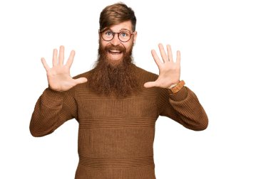 Genç İrlandalı kızıl elbiseli ve gözlüklü adam on numarayı gösterip işaret ederken kendinden emin ve mutlu gülümsüyor.. 