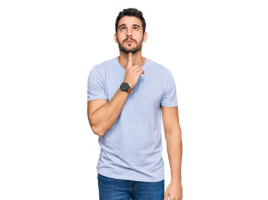 Gündelik kıyafetler giyen genç İspanyol adam şüphe üzerine yoğunlaşmıştı. Parmakları çenesinde ve yukarı bakıyordu. 