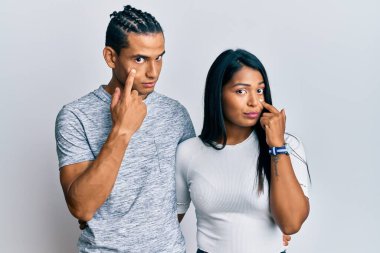 Gündelik giysiler giymiş genç bir çift senin jestini ve şüpheli ifadeni izliyor. 