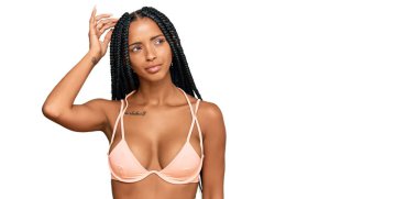 Güzel İspanyol kadın bikini giyiyor ve merak ediyor. Şüpheyle kararsız, kafa kafaya düşünerek. Düşünceli kavram. 