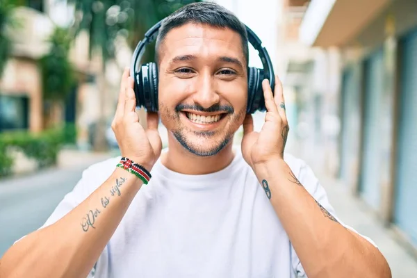 Giovane Uomo Ispanico Sorridente Felice Ascoltare Musica Utilizzando Cuffie Strada — Foto Stock