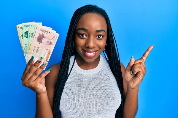 Joven Mujer Afroamericana Sosteniendo Surcoreano Ganó Billetes Sonriendo Feliz Señalando —  Fotos de Stock