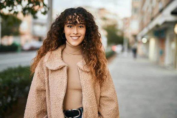 Genç İspanyol kadın gülümseyerek şehirde mutlu mesut dikiliyor.