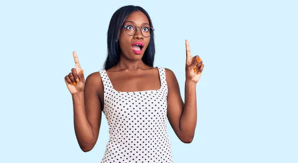 Молодая Африканская Американка Повседневной Одежде Очках Удивлена Удивлена Глядя Вверх — стоковое фото