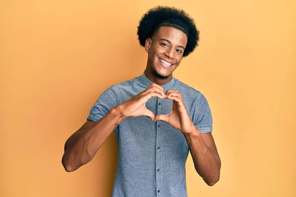 黑头发的非裔美国人穿着休闲装 带着爱心微笑 手握心形符号 浪漫的概念 — 图库照片