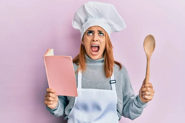 Hispanic Young Chef Woman Reading Recipes Book Angry Mad Screaming — Stock Photo, Image