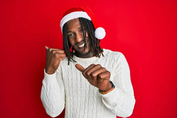 Африканский Американец Косичками Рождественской Шляпе Указывает Спину Поднятой Рукой Большим — стоковое фото