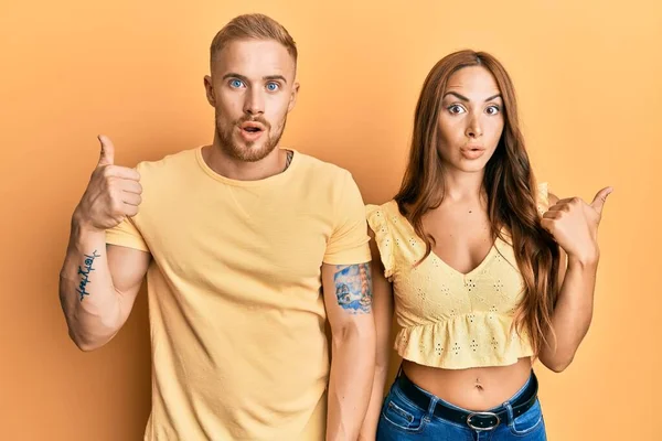 Young Couple Girlfriend Boyfriend Hugging Standing Together Surprised Pointing Hand — Stock Photo, Image