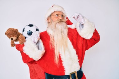 Gri saçlı, uzun sakallı, Noel Baba kostümü giyen, bıyıklı, gülümseyen ve kafasını çeviren yaşlı bir adam.. 