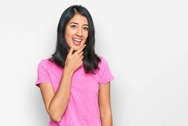 Sıradan pembe tişörtler giyen güzel bir Asyalı kadın kameraya kendinden emin bir şekilde bakıyor kollarını kavuşturmuş ve çenesini kaldırmış gülümsüyor. Olumlu düşünmek. 