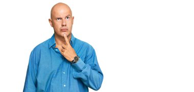 Orta yaşlı kel bir adam günlük giysiler giyip şüpheye odaklanmıştı. Parmakları çenesinde ve yukarı bakıyordu. 