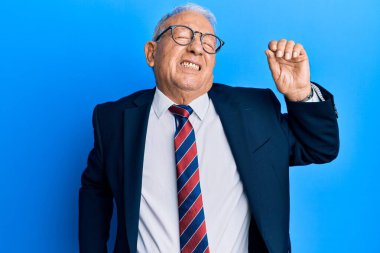 Beyaz adam iş elbisesi ve kravat takıyor, yorgun ve rahat, uykulu ve sabahın erken saatleri için esniyor. 