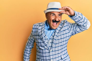 Bıyıklı, klasik ve zarif moda tarzı olan olgun bir Orta Doğulu. Çok mutlu ve tebessüm ediyor. arama kavramı. 