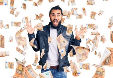 Sıradan deri ceket giyen genç bir Arap çılgın ve başarıyı kollarını kaldırıp heyecanla haykırarak kutluyor. Kazanan konsept