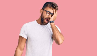 Gündelik kıyafetler giyen ve gözlük takan genç İspanyol adam yarı yüzünü, göz ve ağzını eliyle kapatmaktan yoruldu. Yüzüm acıyor.. 