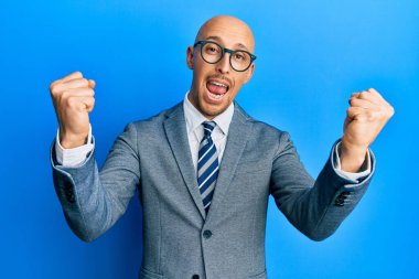 Sakallı, iş ceketli ve gözlüklü kel adam gururla haykırıyor, zaferi kutluyor ve başarıyı kollarını kaldırarak kutluyor. 