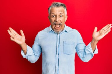 Orta yaşlı, gri saçlı, sıradan kıyafetler giyen, çılgın kutlamalar yapan ve başarıyı kolları açık, gözleri açık heyecanla haykıran bir adam. Kazanan konsept 