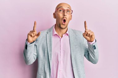 Sakallı, iş elbiseleri ve gözlüklü kel adam şaşırmış ve şaşırmış bir şekilde başını kaldırıp parmaklarıyla işaret ediyor ve kollarını kaldırıyordu.. 