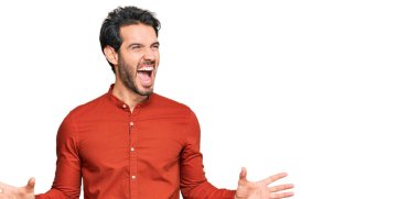 Gündelik kıyafetler giyen genç İspanyol adam deli gibi bağırıyor ve agresif bir ifade ve kollarla bağırıyor. hüsran kavramı. 