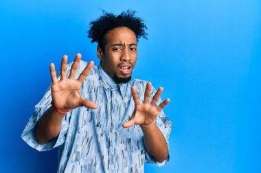 Sakallı, korku ifadesinden korkan ve dehşete düşmüş genç Afrikalı Amerikalı adam. El hareketini durdur, şok içinde bağır. panik konsepti. 