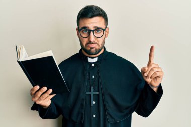 Genç İspanyol rahip elinde İncil 'le bunalıma girmiş ve üzüntüden ağlayan öfkeli ve korkmuş bir halde. hüzünlü ifade. 