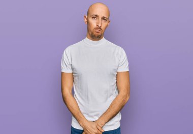 Kel, sakallı, günlük beyaz tişörtlü, bunalımlı, sıkıntılı, sinirli ve korkmuş bir adam. hüzünlü ifade. 
