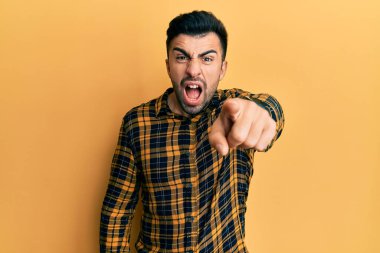 Gündelik kıyafetler giyen genç İspanyol adam kameraya kızgın ve sinirli bir şekilde seni işaret ediyor. 