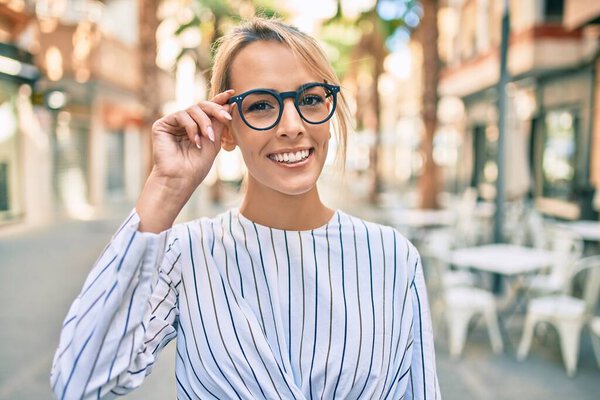 Молодая блондинка-бизнесмен улыбается счастливой прогулке по городу.