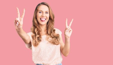 Sarı saçlı, sıradan kıyafetler giyen, dili dışarı fırlamış ve zafer işareti yaparken parmaklarını gösteren güzel beyaz bir kadın. İki numara.. 