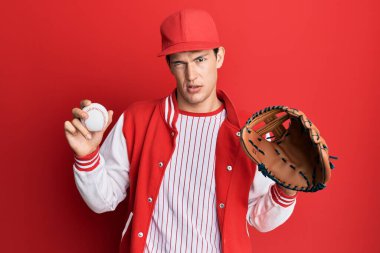 Beyzbol üniforması giyen yakışıklı beyaz adam Golve 'u tutuyor ve topları kuşkucu ve sinirli, sorun yüzünden surat asıyor. negatif kişi. 