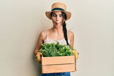 Genç İspanyol kadın elinde yeşil saksıyla balık suratlı ve şaşı gözlü, çılgın ve komik.. 