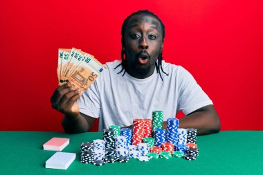 Elinde 50 avroluk banknotlarla poker oynayan yakışıklı genç bir adam. Şaşırtıcı bir şekilde korkmuş ve hayrete düşmüştü. 