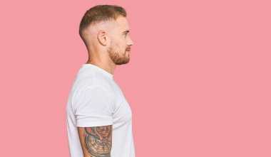 Genç İrlandalı adam günlük giysiler giyiyor. Taraf arıyor, rahat poz veriyor. Kendine güvenen bir gülümseme takınıyor.. 