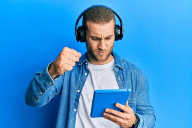 Kulaklık takan genç, beyaz bir adam öfkeyle bağırıyor, öfkeyle bağırıyor ve el kaldırıyor. 